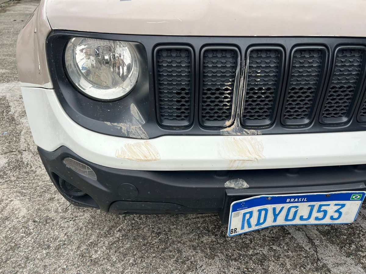 Capô e grade frontal da viatura com sinais do confronto